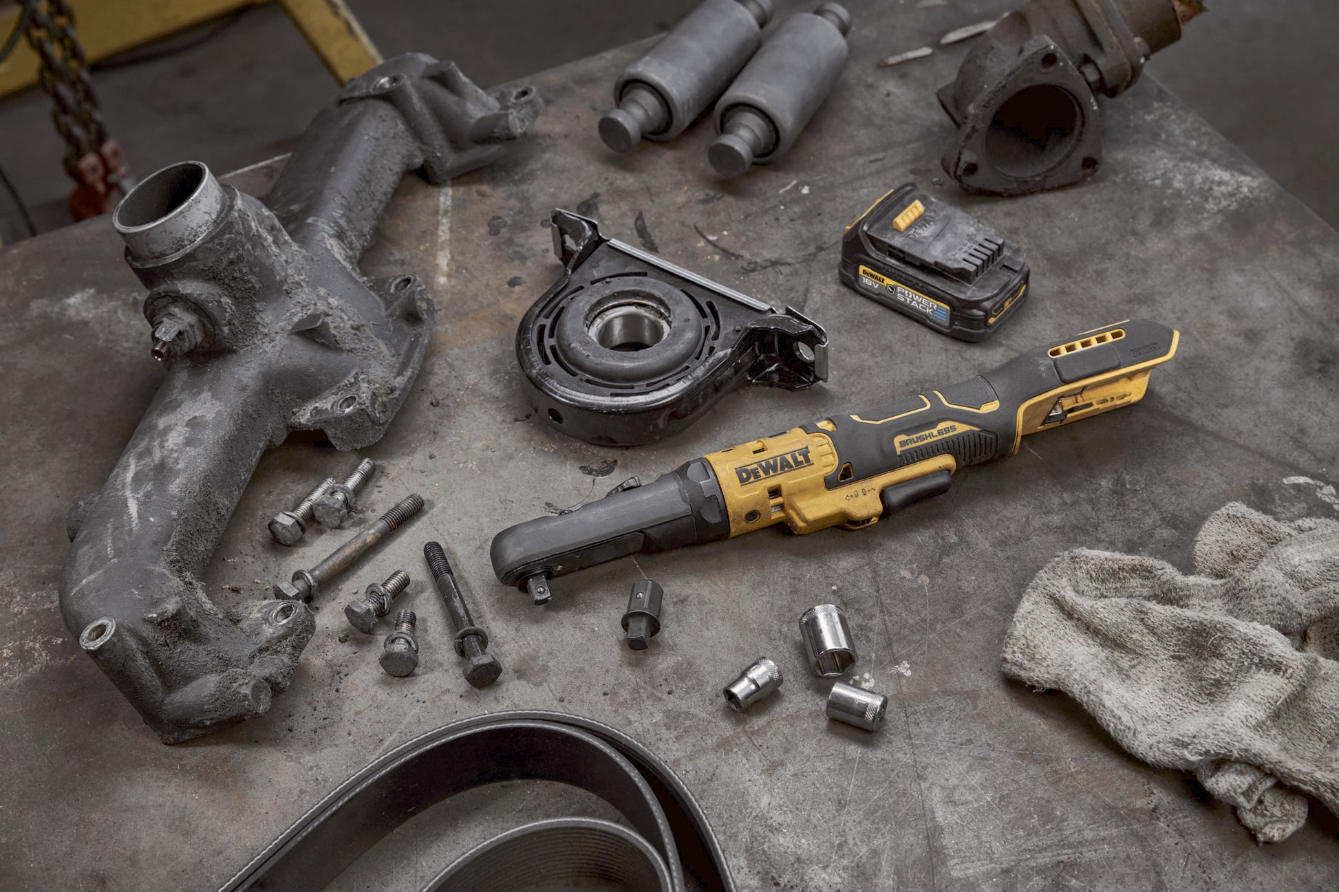 Dewalt DCF510N Akku-Ratsche mit einem Akku liegt auf einer Werkbank neben  Motorbauteilen