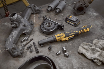 Dewalt DCF510N Akku-Ratsche mit einem Akku liegt auf einer Werkbank neben  Motorbauteilen