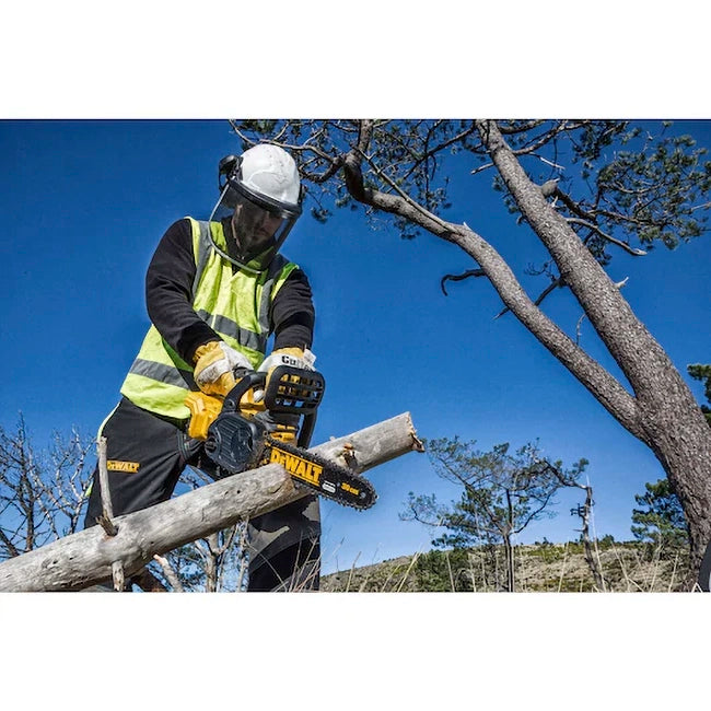 Ein Mann in Schutzkleidung und Schutzhelm sägt mit einer Dewalt DCM565N 18 Volt Akku-Kettensäge einen Baumstamm im Wald